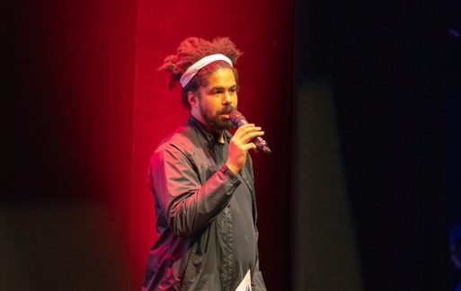 Black man performing spoken word on stage